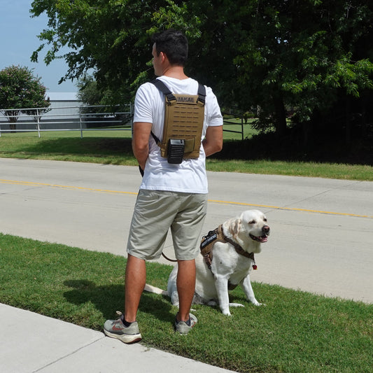 Man with a Jakal Cooling Backpack walking a dog in the summer heat.