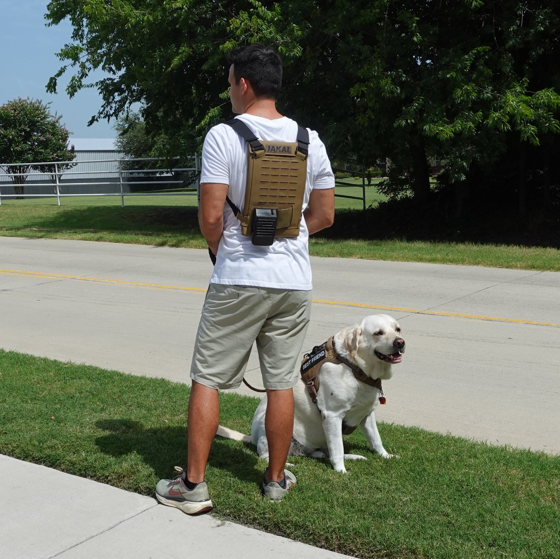 Man with a Jakal Cooling Backpack walking a dog in the summer heat. 